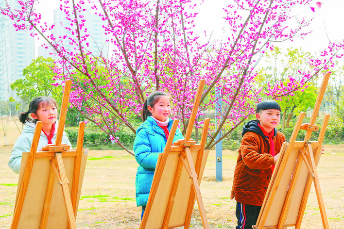 2月28日，在庐阳经开区凌湖路高压廊道公园，南门小学恒盛皇家花园校区的学生正在梅花园内用版画画春。记者 张正朋 通讯员 赵明 摄